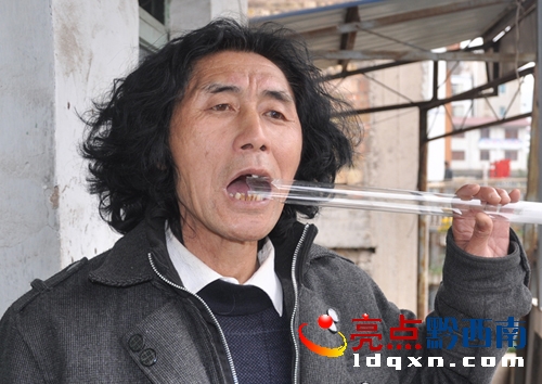 李顯明在他家陽臺(tái)上準(zhǔn)備吃燈管瞬間.JPG