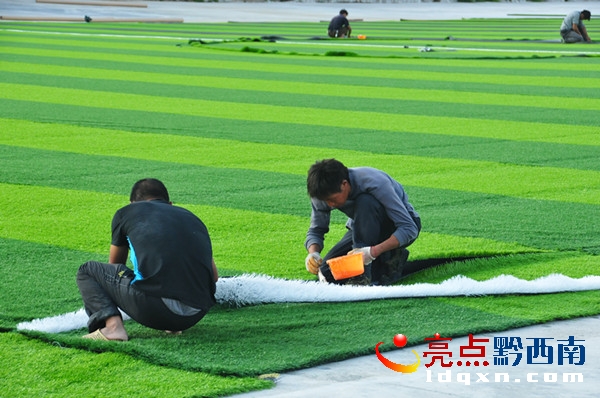 施工人員對(duì)足球場(chǎng)進(jìn)行人造草坪鋪裝（陳亞林?jǐn)z影）.JPG