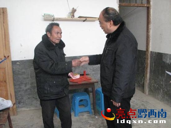 圖為：唐躍林將慰問金送到羅明學手中時情景。.jpg